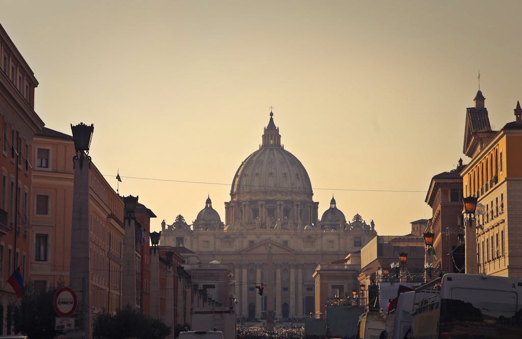 Street view of Saint Peter's Basilica in Vatican City during dusk, capturing the iconic architecture and Roman skyline.